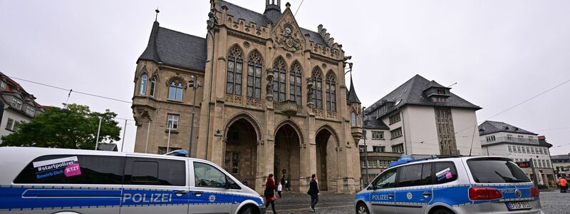 Polizeifahrzeuge stehen nach einer Bombendrohung vor dem Erfurter Rathaus. - Foto: Martin Schutt/dpa
