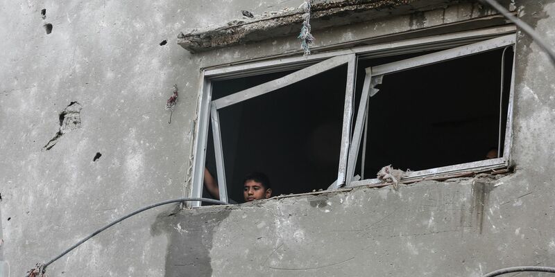 Ein israelischer Panzer ist zu sehen, während Palästinenser das Nasser-Krankenhaus und die angrenzenden Schulen verlassen. - Foto: Mohammed Talatene/dpa
