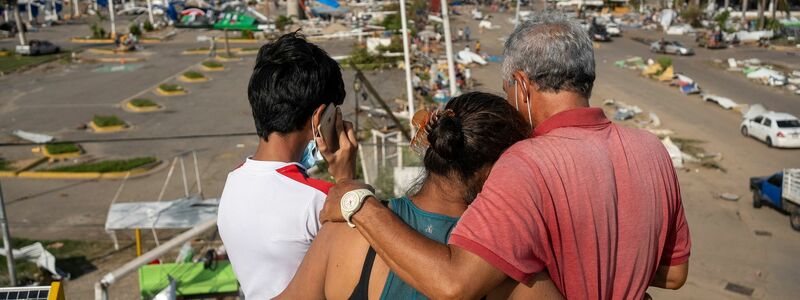 Anwohner betrachten die Schäden, die durch den Hurrikan «Otis» verursacht worden sind. - Foto: Felix Marquez/AP/dpa