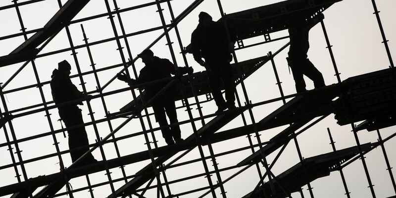 Gerüstbauer errichten ein Gerüst. Die hohe Teuerungsrate und die schwächere Konjunktur dürften die Schwarzarbeit in Deutschland spürbar anheizen. (Symbolbild) - Foto: Christian Charisius/dpa