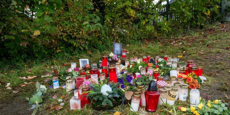 Kerzen und Blumen zum Gedenken: Ein Passant hatte den Toten auf einer Wiese in Horn-Bad Meinberg am Rande des Teutoburger Waldes entdeckt. - Foto: Sebastian Vogt/Stadt Horn-Bad Meinberg/dpa