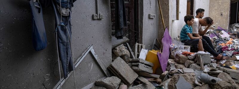 Nachdem es von einem israelischen Luftangriff getroffen wurde, sitzen Palästinenser auf den Trümmern eines Hauses Chan Junis. - Foto: Fatima Shbair/AP
