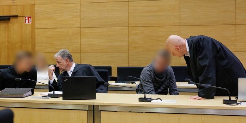 Christian Thüner (2.v.l) und Jerrit Schöll (r), die Verteidiger der Angeklagten, sprechen mit ihren Mandanten in einem Saal des Landgericht Bielefeld zum Auftakt im Prozess um ein illegales Motorradrennen mit Todesfolge. - Foto: Friso Gentsch/dpa