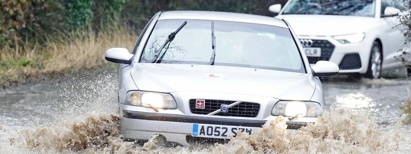 Autos fahren durch das Hochwasser in der Nähe von Whitley Bay an der Nordostküste Englands. Das aufziehende Sturmtief bereits für heftigen Regen gesorgt. - Foto: Owen Humphreys/PA Wire/dpa