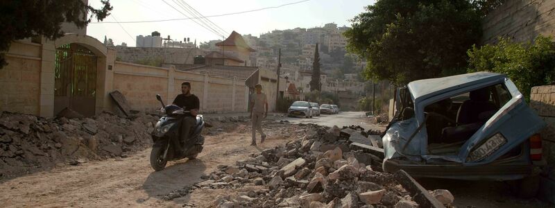 Palästinenser inspizieren die Zerstörung eines Gebiets nach schweren Zusammenstößen während einer israelischen Razzia im Flüchtlingslager Dschenin. - Foto: Stringer/dpa