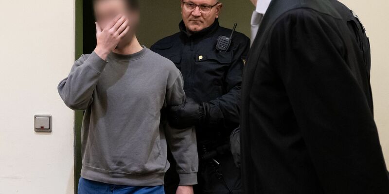 Der Angeklagte (l) wird während des Prozesses vor dem OLG München in den Verhandlungssaal geführt (Archivbild). - Foto: Sven Hoppe/dpa