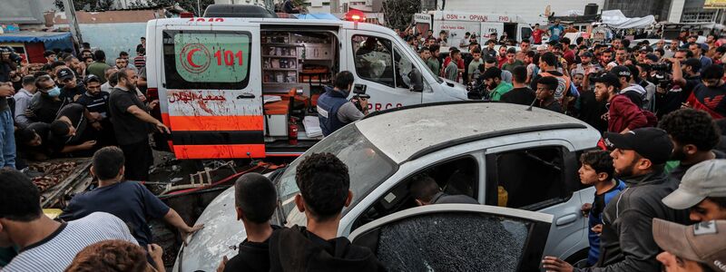 Menschen versammeln sich um einen Krankenwagen, nachdem dieser vor dem Eingang des Schifa-Krankenhaus angegriffen wurde. - Foto: -/XinHua/dpa