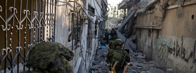 Israelische Soldaten gehen zwischen zerstörten Häusern: Israels Militär hat nach eigenen Angaben die Stadt Gaza umstellt. - Foto: HO/Israel Defense Forces/AP/dpa
