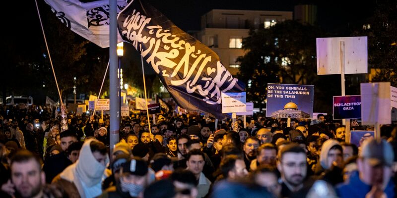 Eine Fahne mit arabischer Schrift bei der Kundgebung. Begleitet von starken Kräften der Polizei demonstrierten die Teilnehmer gegen den israelischen Militäreinsatz im Gazastreifen. - Foto: Christoph Reichwein/dpa