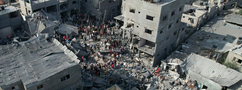 Palästinenser durchsuchen die Trümmer nach einem israelischen Bombardement im Flüchtlingslager Al-Magasi im Gazastreifen. - Foto: Hatem Moussa/AP/dpa