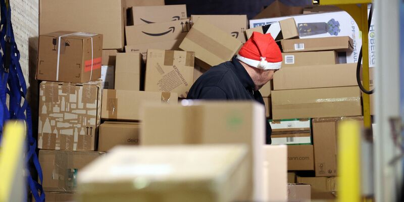 In einer Zustellbasis von DHL wird ein LKW mit Paketen entladen. - Foto: Bernd Wüstneck/dpa