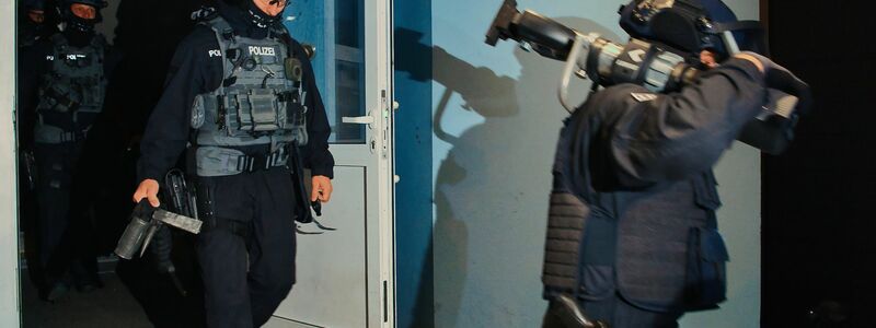 Spezialkräfte verlassen bei einer großangelegten Razzia der Bundespolizei und Landespolizei Brandenburg ein Haus in Weißensee. - Foto: Paul Zinken/dpa