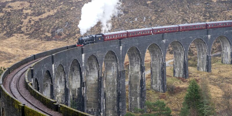 Der erste Jacobite Express der Saison 2022 überquert das Glenfinnan-Viadukt auf seinem Weg von Fort William nach Mallaig. Die «Harry Potter»-Filme machten die Zugstrecke über das Glenfinnan-Viadukt in Schottland weltberühmt. - Foto: Jane Barlow/PA Archive/dpa