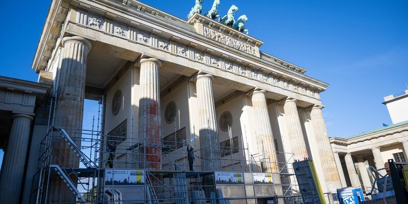 Auf einer Seite des Brandenburger Tors wird ein Baugerüst aufgebaut, um die Folgen der Farbattacke zu beseitigen. - Foto: Christophe Gateau/dpa