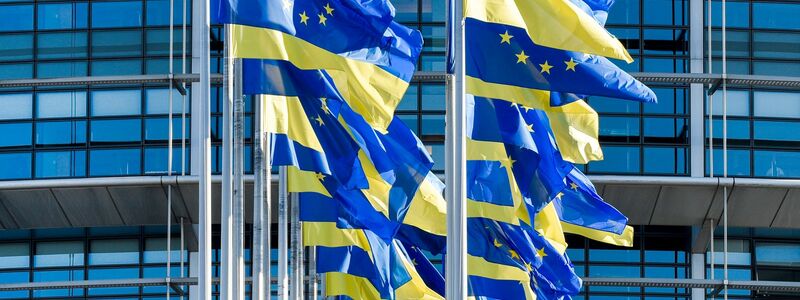 Europäische und ukrainische Flaggen wehen vor dem Europäischen Parlament in Straßburg. Die EU-Kommission erklärt die positive Empfehlung für das osteuropäische Land damit, dass die noch ausstehenden Reformen bereits auf den Weg gebracht seien. - Foto: Pascal Bastien/AP/dpa