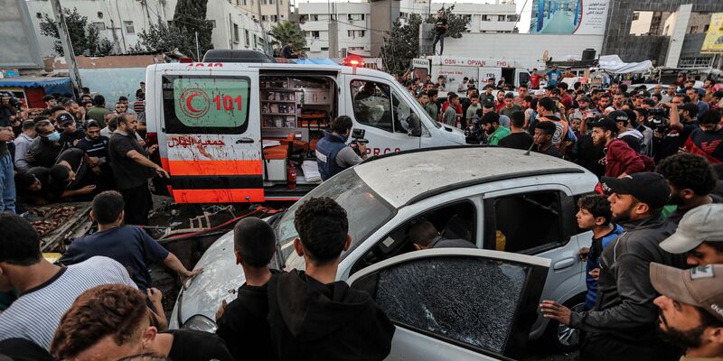 Menschen versammeln sich um einen Krankenwagen, nachdem dieser vor dem Eingang des Schifa-Krankenhaus angegriffen wurde. - Foto: -/XinHua/dpa