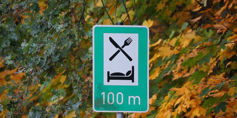 Ein Schild weist auf die Möglichkeit zum Essen und Übernachten hin: Die Übernachtungszahlen steigen. - Foto: Soeren Stache/dpa