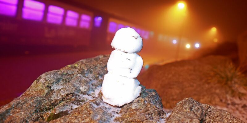 Ein kleiner Schneemann steht auf einem Stein auf dem Brocken. - Foto: Matthias Bein/dpa