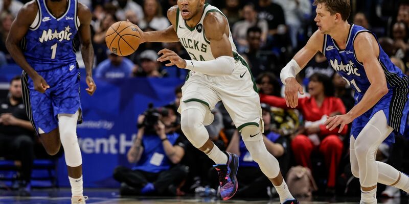 Milwaukees Giannis Antetokounmpo (M) dribbelt an Orlandos Jonathan Isaac (l) und Center Moritz Wagner (21) vorbei. - Foto: Kevin Kolczynski/AP/dpa