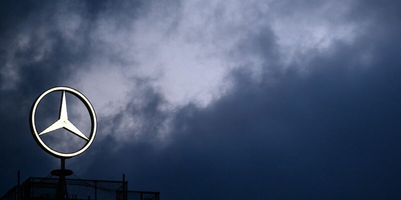 Dunkle Wolken über dem Mercedes Stern. - Foto: Sebastian Gollnow/dpa