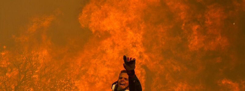 Ein Feuerwehrmann kämpft in dem Dorf in der Nähe von Athen gegen einen Waldbrand. Die Vereinten Nationen fürchten durch den Klimawandel eine Zunahme von Katastrophen mit schweren Auswirkungen auf Landwirtschaft und Ernährungssicherheit. - Foto: Marios Lolos/XinHua/dpa
