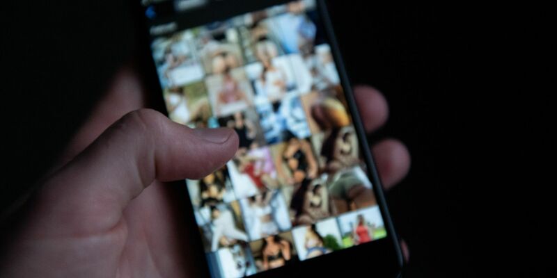 Auf einem Smartphone sind pornografische Bilder zu sehen. - Foto: Silas Stein/dpa
