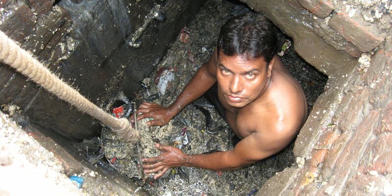 Ein Kanalreiniger arbeitet in einem Außenbezirk von Neu Delhi in der Kanalisation - ohne Schutzkleidung. - Foto: -/Organisation SKA/dpa