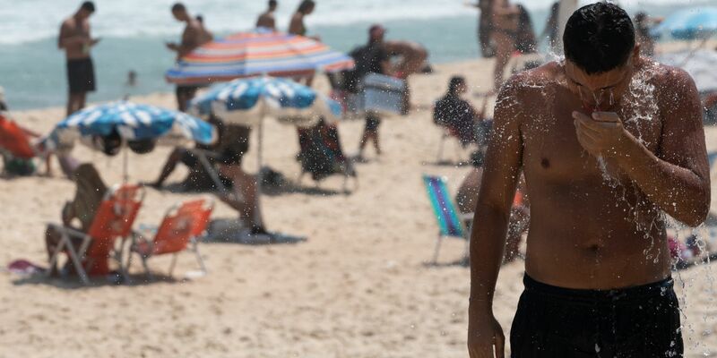 Ein Mann duscht am Strand von Ipanema. Brasilien wird derzeit von einer Hitzewelle heimgesucht. - Foto: Wang Tiancong/XinHua/dpa