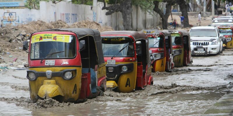 Tuktuks fahren durch eine überflutete Straße nach starkem Regen in Mogadischu. - Foto: Farah Abdi Warsameh/AP/dpa