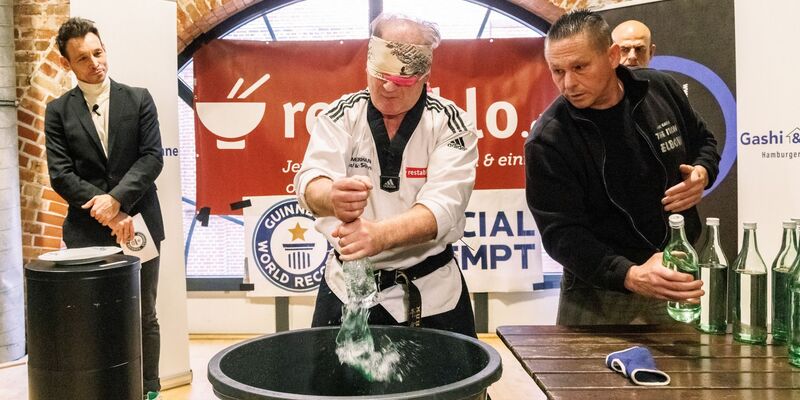 Der Kampfsportler Muhamed Kahrimanovic beim Versuch, mit verbundenen Augen und einem rohen Ei in der Hand Glasflaschen zu zerschlagen. - Foto: Markus Scholz/dpa
