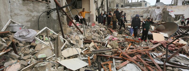 Palästinenser suchen in den Trümmern eines Gebäudes nach Überlebenden. - Foto: Hatem Ali/AP