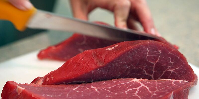 Rindfleisch wird geschnitten: Italien verbietet die Herstellung und den Verkauf von Laborfleisch. - Foto: Oliver Berg/dpa