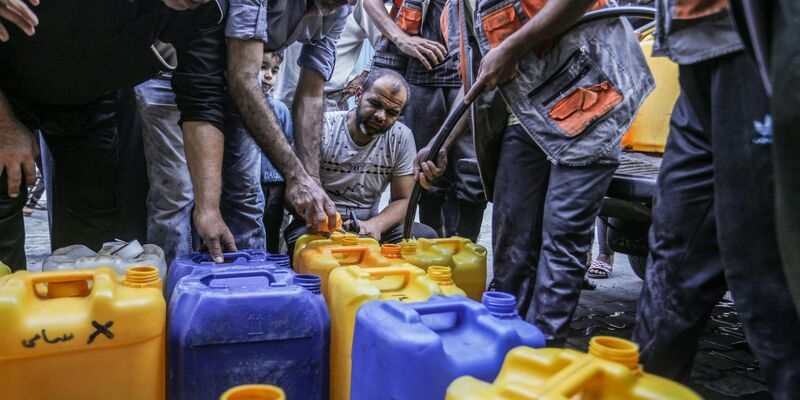 Palästinenser stehen Schlange, um Wasser zu bekommen. - Foto: Abed Rahim Khatib/dpa