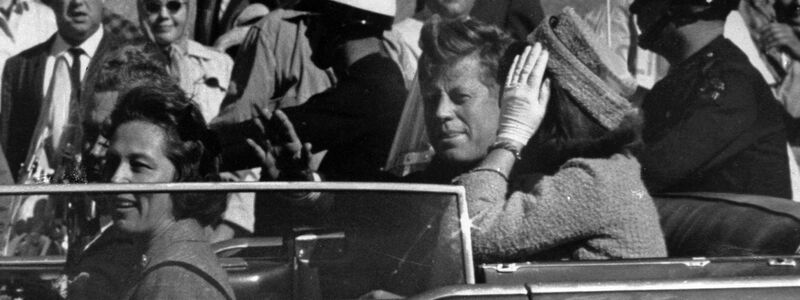 Kurz vor seiner Ermordung sitzt der damalige US-Präsident John F. Kennedy am 22.11.1963 in Dallas zusammen mit seiner Frau Jacqueline Kennedy (r) sowie dem dem Gouverneur von Texas, John Connally, und desen Frau Nellie Connally in einer offenen Limousine. - Foto: ---/AP/dpa