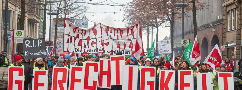 «Gerechtigkeit» - Teilnehmer ziehen beim «Stadtstaatenstreik» durch die Hamburger Mönckebergstraße. - Foto: Georg Wendt/dpa