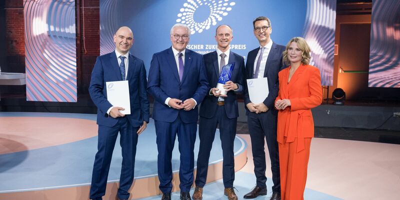 David M. Grodzki (l-r), Bundespräsident Frank-Walter Steinmeier, Stephan Biber, Michael Uder und Moderation Yve Fehring stehen nach der Verleihung des Deutschen Zukunftspreises 2023 zusammen. - Foto: Sebastian Christoph Gollnow/dpa