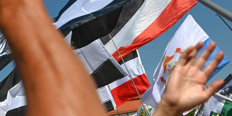 Reichsflaggen werden auf dem Magdeburger Domplatz zu einer «Reichsbürger»-Kundgebung hochgehalten. - Foto: Heiko Rebsch/dpa