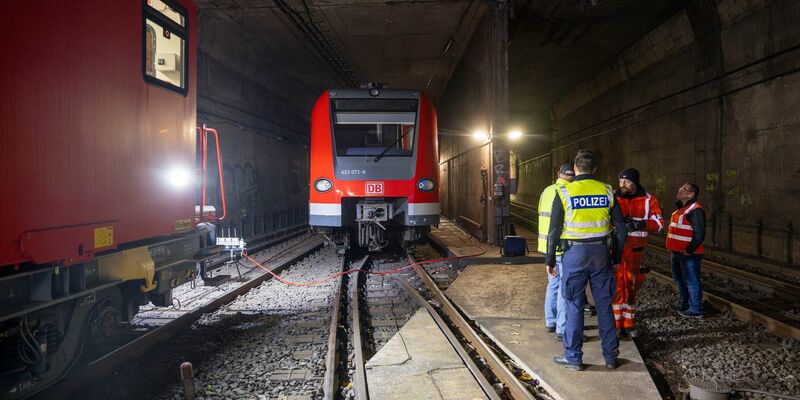Bundespolizisten und Bahnarbeiter stehen in den Morgenstunden an der entgleisten S-Bahn im Tunnel hinter der Haltestelle Isartor. - Foto: Peter Kneffel/dpa