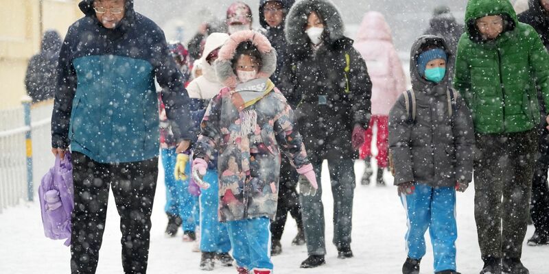 Eltern bringen ihre Kinder in Harbin zur Schule. - Foto: Wang Jianwei/XinHua/dpa