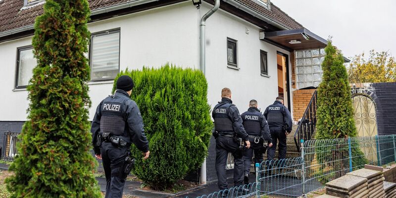 Polizeibeamte durchsuchen ein Haus in einer Wohnsiedlung in Garbsen. - Foto: Ole Spata/dpa
