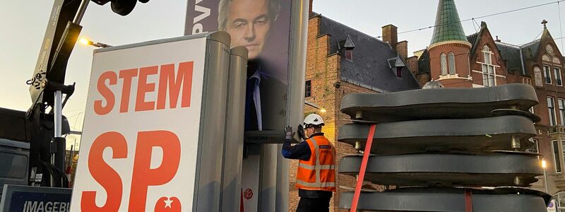Ein Wahlkampfplakat der PVV-Partei mit dem Konterfei des Spitzenkandidaten Wilders wird am Morgen nach der Wahl entfernt. - Foto: Aleksandar Furtula/AP/dpa