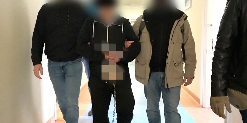 Polizisten bringen den mutmaßlichen Doppelmörder (M) zur Vernehmung bei der Bezirksstaatsanwaltschaft Warschau. - Foto: Warschauer Polizeikommandantur/Warschauer Bezirksanwaltschaft/dpa