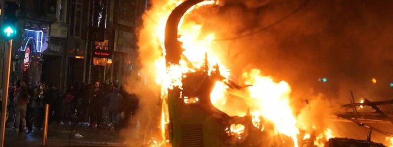 Ein Bus steht im Stadtzentrum in Flammen. - Foto: Brian Lawless/PA Wire/dpa