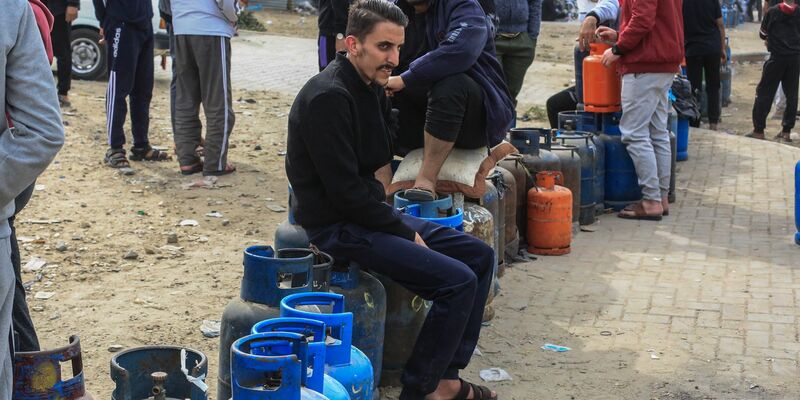 Am zweiten Tag der viertägigen Feuerpause zwischen Israel und der Terrororganisation Hamas stehen Palästinenser Schlange, um ihre Flüssiggasflaschen aufzufüllen. - Foto: Mohammed Talatene/dpa
