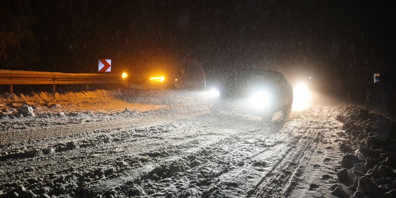 Autofahrer sind auf einer verschneiten Straße bei Niedernhausen unterwegs. - Foto: Jörg Halisch/dpa