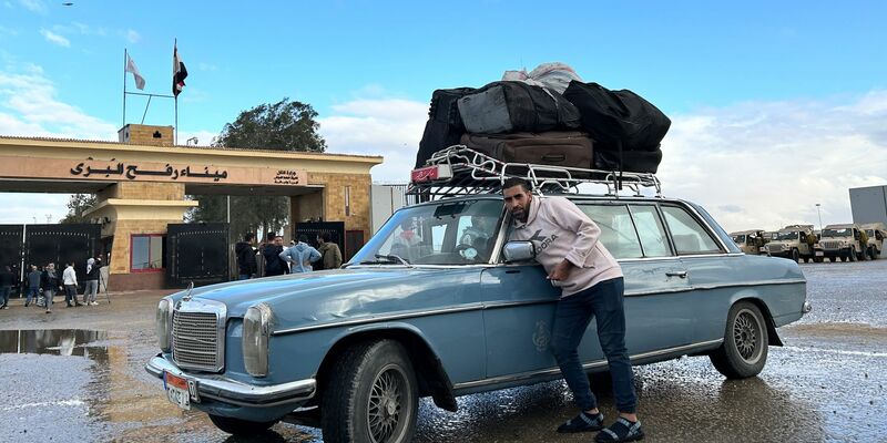 Ein Fahrer, der Palästinenser zur Rückkehr in den Gazastreifen zur Grenze bringt, steht auf der ägyptischen Seite am Grenzübergang Rafah. - Foto: Johannes Sadek/dpa