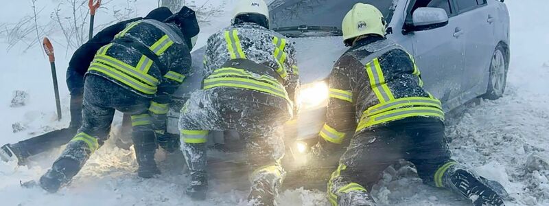 Ukrainische Rettungskräfte versuchen, ein im Schnee steckengebliebenes Auto auf der Autobahn in der Region Odessa zu bergen. - Foto: -/Rettungsdienst der Ukraine via AP/dpa