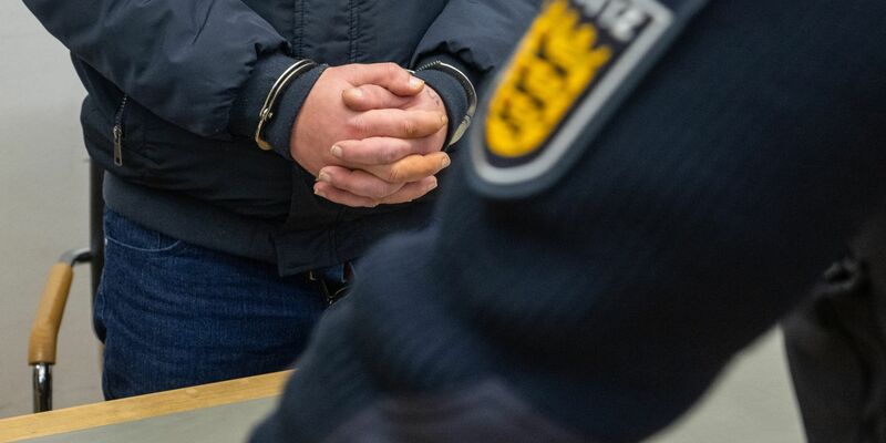 Der angeklagte 41-Jährige steht mit Handschellen im Landgericht. Er gab zu, im Frühjahr 2023 auf einem Schulhof seine siebenjährige Tochter ermordet zu haben. - Foto: Stefan Puchner/dpa