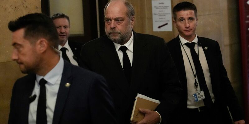 Der französische Justizminister Éric Dupond-Moretti (M) trifft im Gericht ein. Der Minister muss sich wegen angeblicher Interessenkonflikte und Amtsmissbrauchs verantworten. - Foto: Christophe Ena/AP/dpa