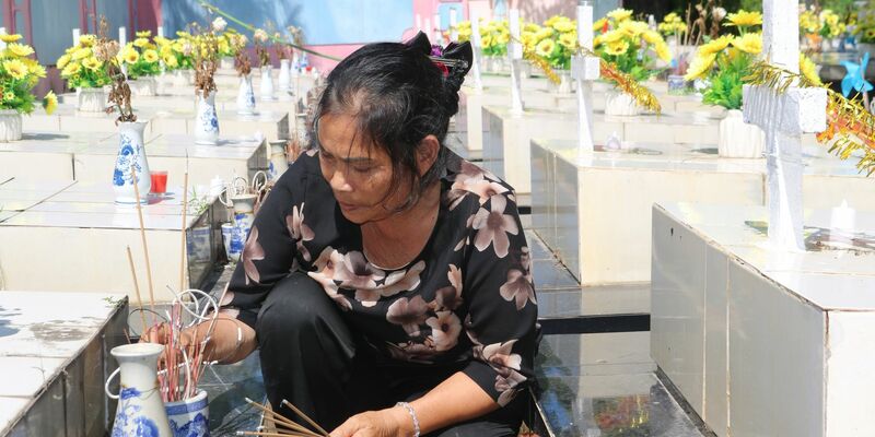 Nguyen Thi Nhiem zündet Räucherstäbchen auf einem Friedhof an und betet für die Seelen der ungeborenen Kinder. - Foto: Bac Pham/dpa
